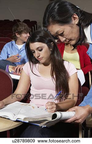 Stock Photo - Teacher explaining something to female student. Fotosearch