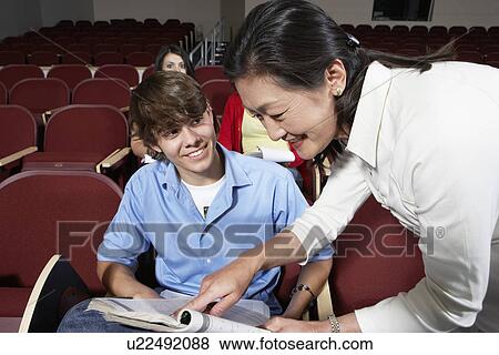 Teacher explaining something to male student View Large Photo Image Stock Photo - Teacher explaining something to male student. Fotosearch