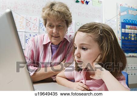 Teacher Helping Schoolgirl Use Laptop View Large Photo Image Stock Photography - Teacher Helping Schoolgirl Use Laptop. Fotosearch