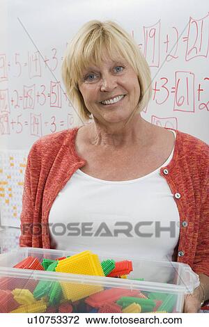 Teacher Holding a Box Full of Plastic Puzzle Pieces View Large Photo Image Stock Image - Teacher Holding a Box Full of Plastic Puzzle Pieces. Fotosearch