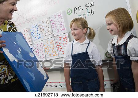 Stock Photo - Teacher Holding Painting. Fotosearch