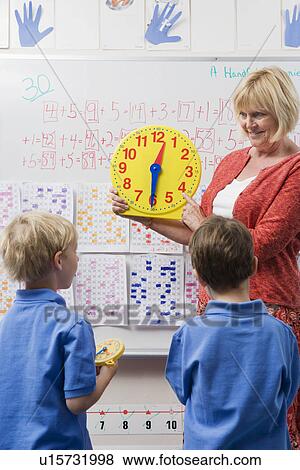 Teacher Teaching Kids to Tell Time View Large Photo Image Stock Photo - Teacher Teaching Kids to Tell Time. Fotosearch