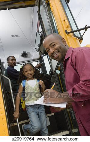 Picture - Teacher Unloading Elementary Students from School Bus. Fotosearch