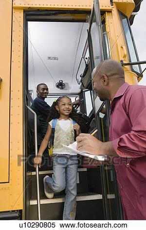 Stock Photography - Teacher Unloading Elementary Students from School Bus. Fotosearch