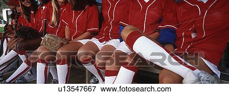 Stock Photo - Teenage (13-17) baseball team sitting on bench, mid section. Fotosearch
