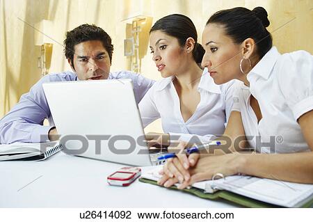 Three business colleagues using laptop in office View Large Photo Image Stock Image - Three business colleagues using laptop in office. Fotosearch