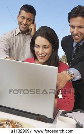 Three business people in front of laptop View Large Photo Image Stock Photo - Three business people in front of laptop. Fotosearch
