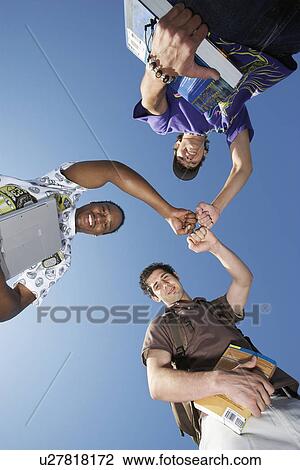 Three male college students with textbooks, view from below View Large Photo Image Stock Image - Three male college students with textbooks, view from below. Fotosearch