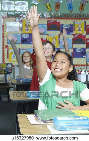 Stock Image - Three pupils with raised hands. Fotosearch