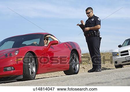 Traffic cop standing by sports car View Large Photo Image Stock Photo - Traffic cop standing by sports car. Fotosearch