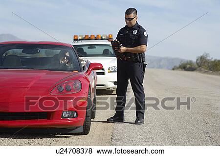 Stock Photo - Traffic cop standing by sports car. Fotosearch