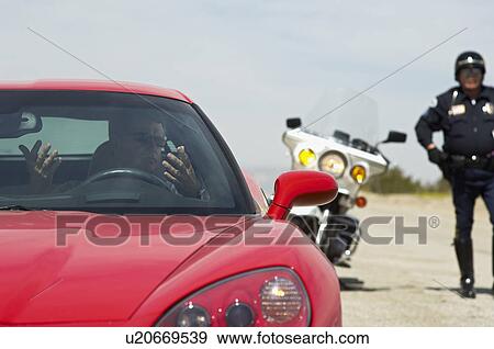 Stock Photo - Traffic cop stopping sports car. Fotosearch