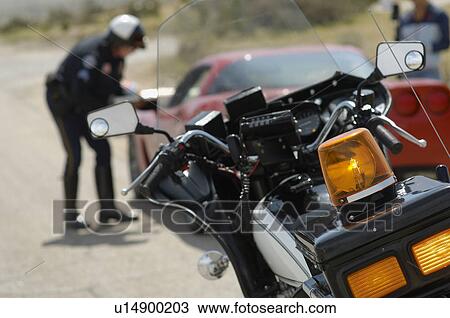 Traffic cop talking with car driver, focus on motorcycle in foreground View Large Photo Image Stock Image - Traffic cop talking with car driver, focus on motorcycle in foreground. Fotosearch