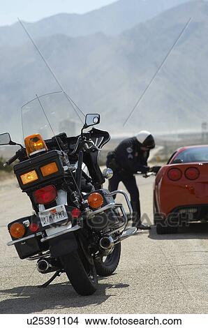 Traffic cop talking with sports car driver, focus on motorcycle in foreground View Large Photo Image Picture - Traffic cop talking with sports car driver, focus on motorcycle in foreground. Fotosearch