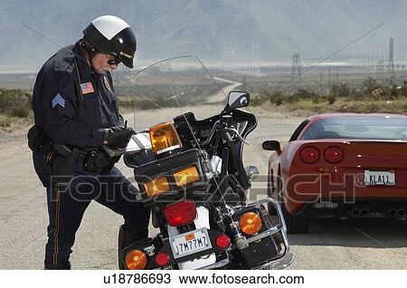 Traffic cop writing against motorcycle on country road View Large Photo Image Stock Image - Traffic cop writing against motorcycle on country road. Fotosearch