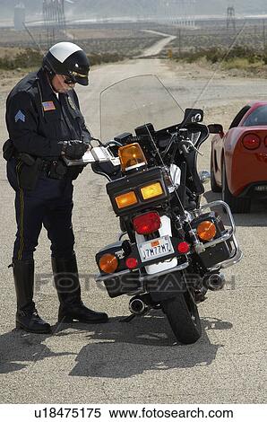 Traffic cop writing against motorcycle on country road View Large Photo Image Stock Photography - Traffic cop writing against motorcycle on country road. Fotosearch