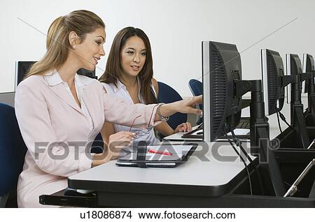 Two business women sitting in computer classroom View Large Photo Image Picture - Two business women sitting in computer classroom. Fotosearch