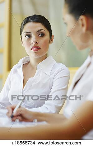 Picture - Two business women sitting in meeting. Fotosearch