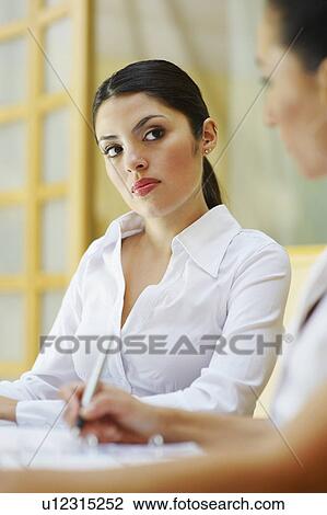Stock Image - Two business women sitting in meeting. Fotosearch