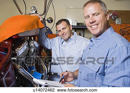 Stock Image - Two mechanics at work. Fotosearch