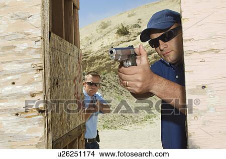 Two men aiming hand guns at firing range View Large Photo Image Picture - Two men aiming hand guns at firing range. Fotosearch