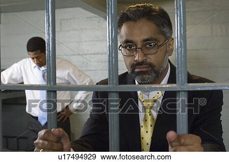 Stock Photo - Two men behind bars. Fotosearch