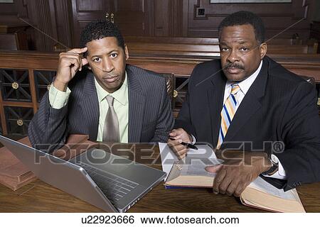 Stock Photograph - Two men sitting in court, portrait. Fotosearch