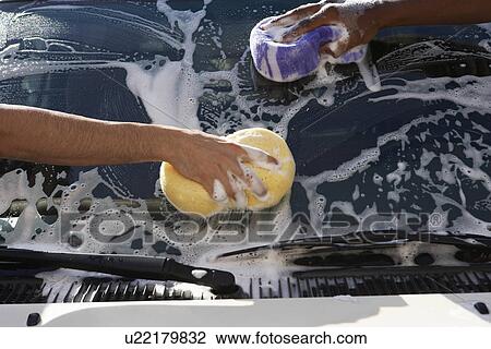 Stock Image - Two men washing windshield, close up of hands. Fotosearch