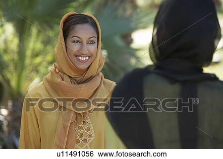 Two muslim woman in traditional clothing talking View Large Photo Image Stock Photograph - Two muslim woman in traditional clothing talking. Fotosearch