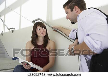 Stock Photo - Two students talking on stairs in school. Fotosearch