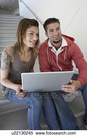 Stock Photography - Two students using laptop on stairs. Fotosearch