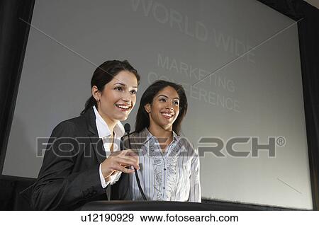 Stock Photo - Two women speaking during conference. Fotosearch
