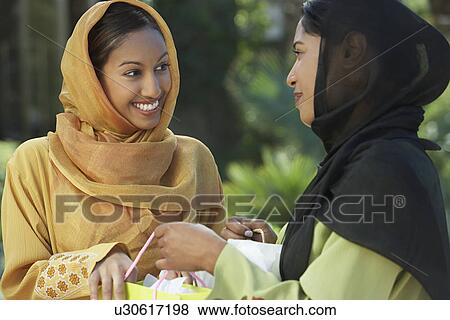 Stock Photo - Two young muslim women talking outdoors. Fotosearch