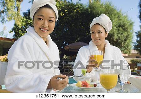 Two young women eating breakfast at outdoor table View Large Photo Image Stock Image - Two young women eating breakfast at outdoor table. Fotosearch