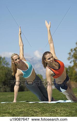 Stock Photo - Two young women exercising in park. Fotosearch