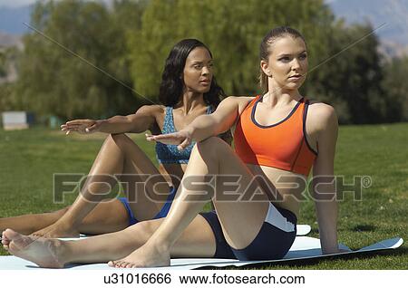 Stock Photograph - Two young women exercising in park. Fotosearch