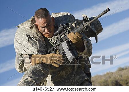 Stock Photo - US Army soldier carrying wounded soldier. Fotosearch