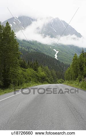 Stock Image - USA, Alaska, empty road in mountains. Fotosearch