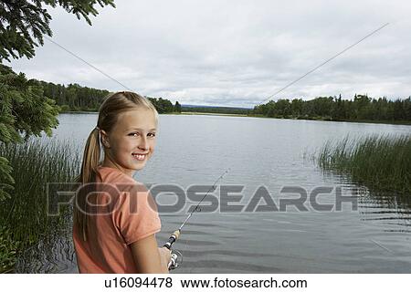 Stock Photo - USA, Alaska, teenage girl fishing at lake, portrait. Fotosearch