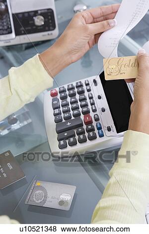 Stock Photo - Woman Adding up Credit Card Charges. Fotosearch