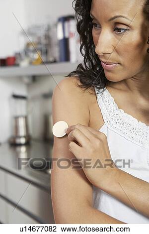 Woman applying patch to arm, indoors, close-up View Large Photo Image Stock Image - Woman applying patch to arm, indoors, close-up. Fotosearch