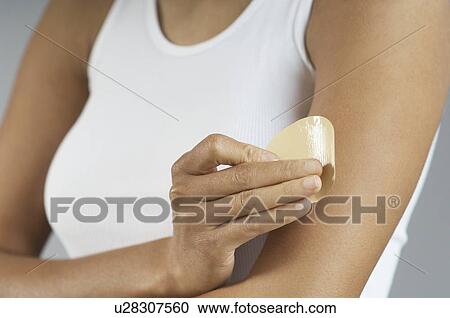 Woman applying patch to arm, mid section View Large Photo Image Stock Image - Woman applying patch to arm, mid section. Fotosearch
