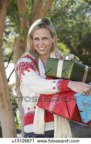 Woman carrying presents outside, portrait View Large Photo Image Stock Image - Woman carrying presents outside, portrait. Fotosearch