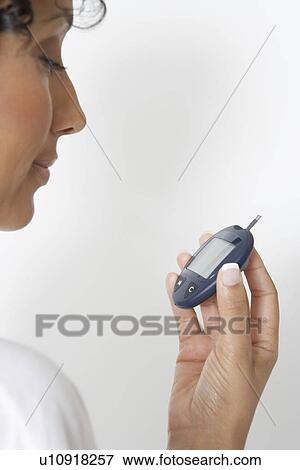 Woman checking diabetes test, close-up, studio shot View Large Photo Image Stock Photo - Woman checking diabetes test, close-up, studio shot. Fotosearch
