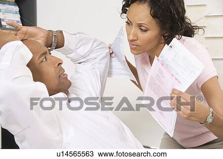 Stock Image - Woman Confronting Man About Bills. Fotosearch