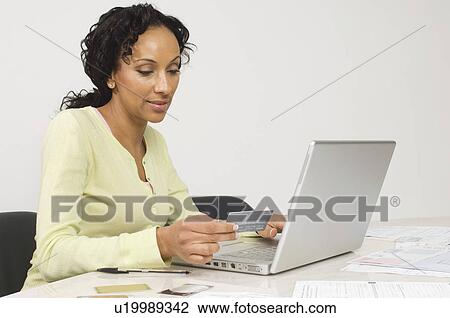 Stock Image - Woman Doing an Online Transaction. Fotosearch