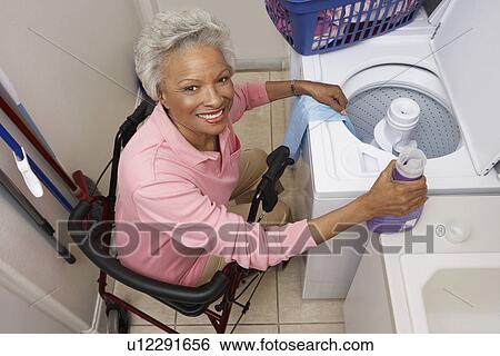 Stock Photograph - Woman doing laundry at home. Fotosearch