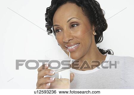 Stock Photograph - Woman drinking glass of water, studio shot. Fotosearch