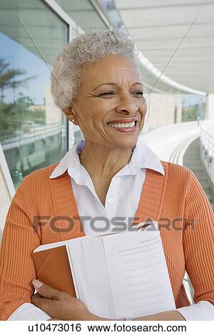 Stock Photograph - Woman embracing book at school. Fotosearch