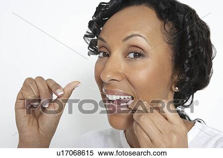 Woman flossing teeth, studio shot View Large Photo Image Stock Photography - Woman flossing teeth, studio shot. Fotosearch